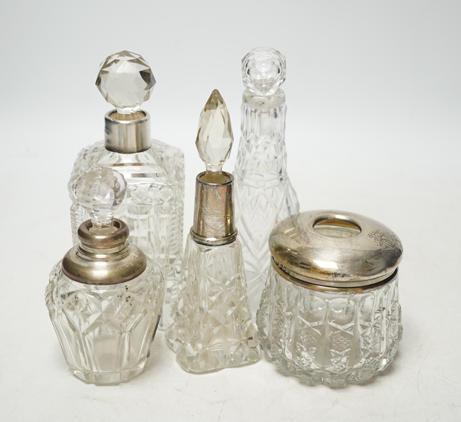 A collection of mainly early 20th century silver mounted glass toilet jars, scent bottles, condiments etc. largest a pair, London, 1895, 15.8cm. Condition - poor to fair